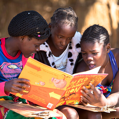 Three children reading a book